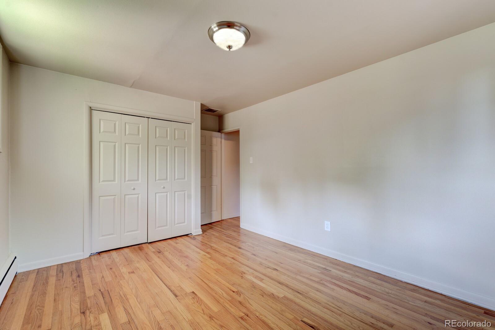 7928 Raleigh Place Westminster, CO 80030 - Photo 17 of 24 a view of empty room with wooden floor