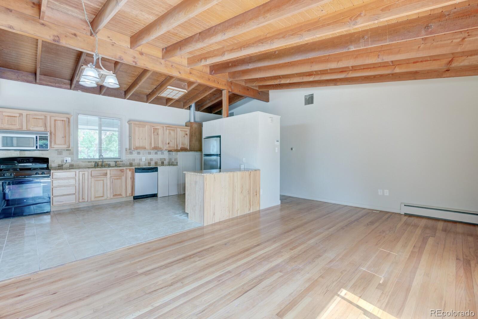 7928 Raleigh Place Westminster, CO 80030 - Photo 2 of 24 a view of a kitchen with refrigerator and wooden floor