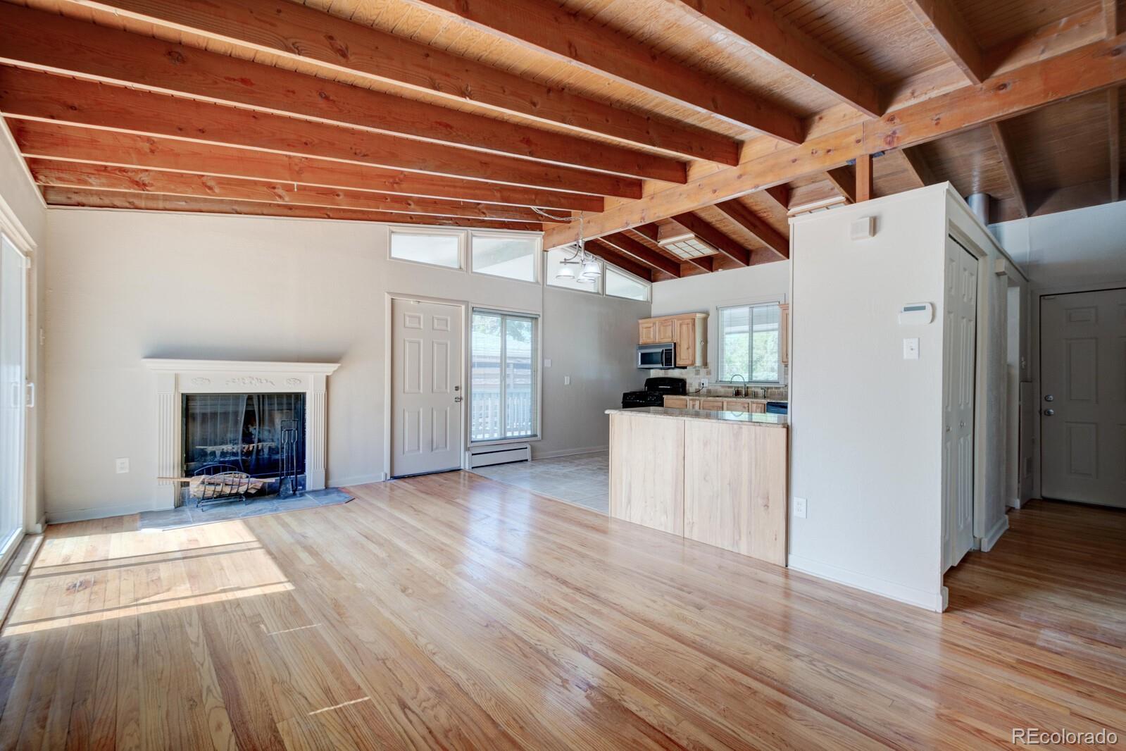 7928 Raleigh Place Westminster, CO 80030 - Photo 3 of 24 a view of empty room with wooden floor and fireplace