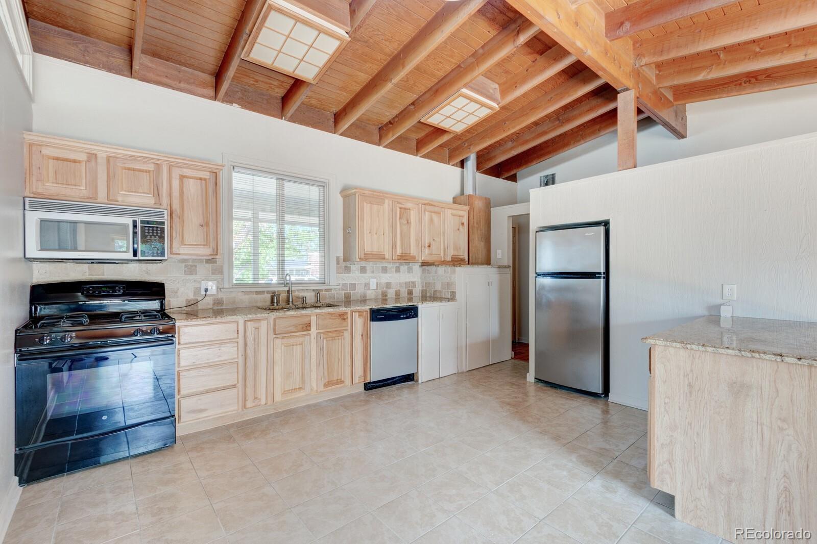 7928 Raleigh Place Westminster, CO 80030 - Photo 6 of 24 a kitchen with refrigerator cabinets and stainless steel appliances