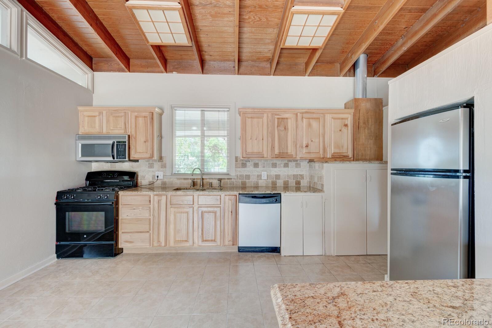 7928 Raleigh Place Westminster, CO 80030 - Photo 7 of 24 a kitchen with white cabinets and stainless steel appliances
