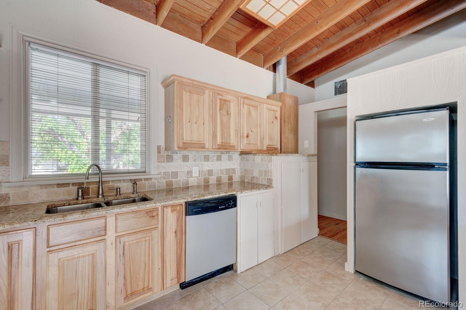 7928 Raleigh Place Westminster, CO 80030 - Photo 9 of 24 a kitchen with white cabinets and a refrigerator