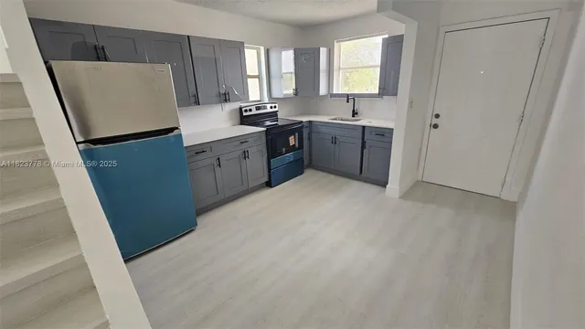 a kitchen with a sink a stove and cabinets