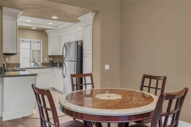 a kitchen with granite countertop white cabinets and stainless steel appliances
