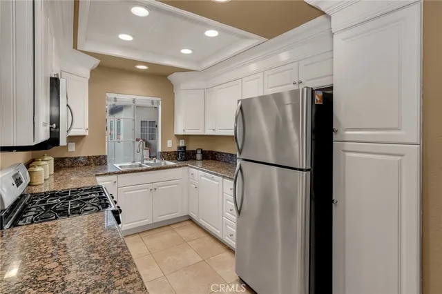 a kitchen with stainless steel appliances granite countertop a refrigerator sink and stove