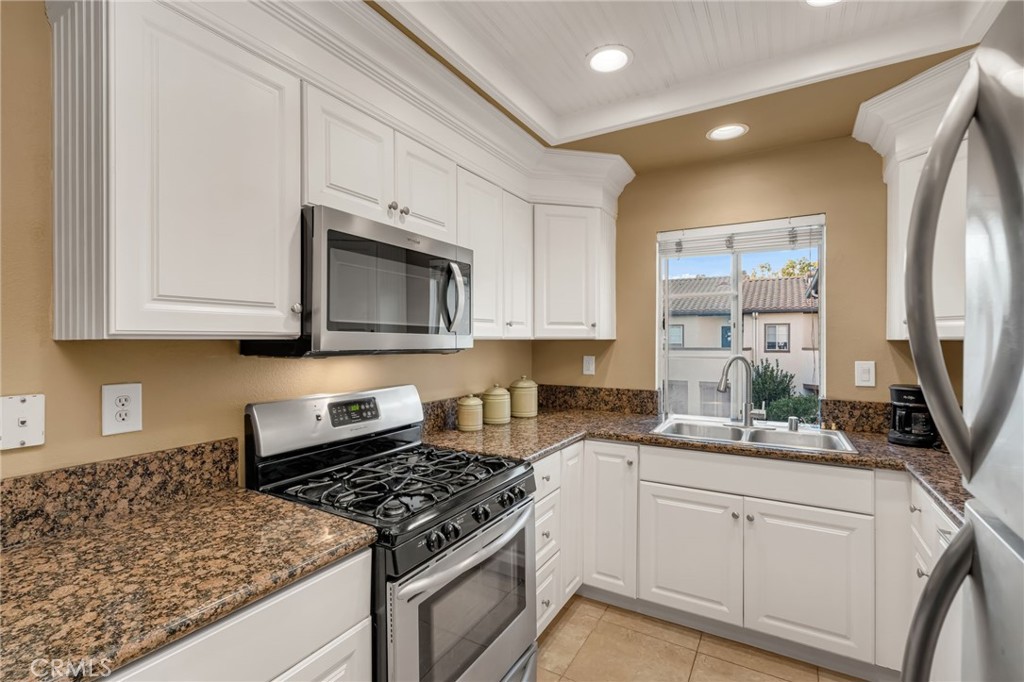 28 Vía Contento Rancho Santa Margarita, CA 92688 - Photo 10 of 61 a kitchen with stainless steel appliances granite countertop a sink stove and microwave