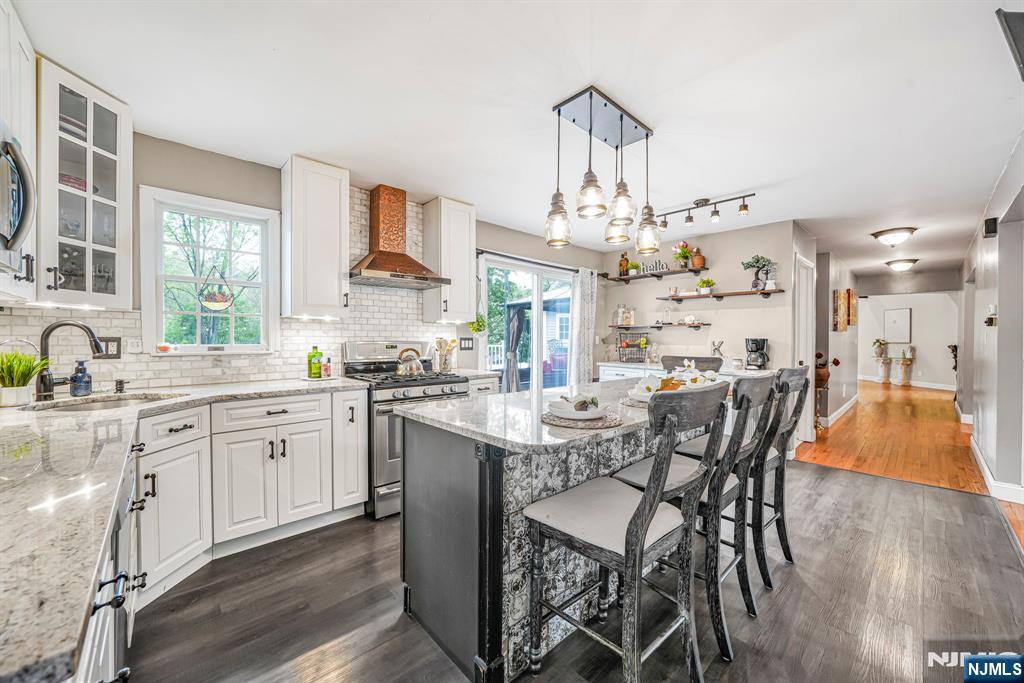 30 Oakley Way Wayne, NJ 07470 - Photo 5 of 43 a kitchen with stainless steel appliances a dining table chairs and granite counter tops