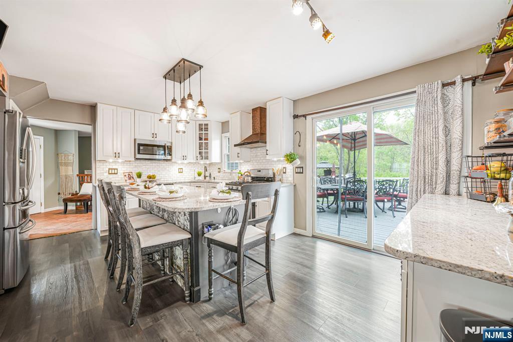 30 Oakley Way Wayne, NJ 07470 - Photo 6 of 43 a dining room with wooden floor a chandelier a glass table and chairs