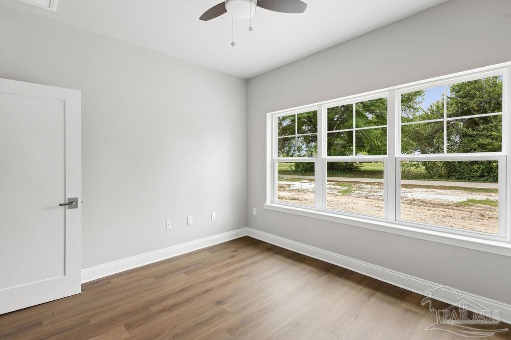 5307 Edeker Circle Jay, FL 32565 - Photo 13 of 28 an empty room with wooden floor and windows