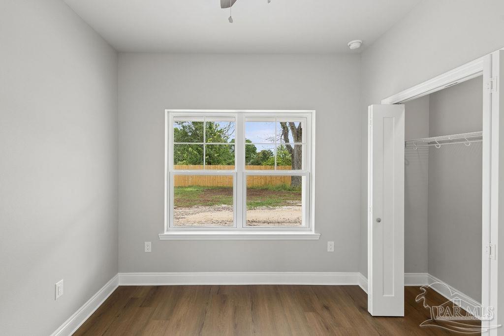 5307 Edeker Circle Jay, FL 32565 - Photo 16 of 28 an empty room with wooden floor and windows