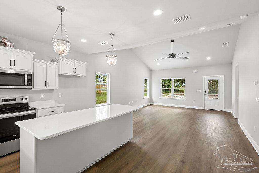 5307 Edeker Circle Jay, FL 32565 - Photo 9 of 28 a large kitchen with granite countertop a stove and a wooden floors