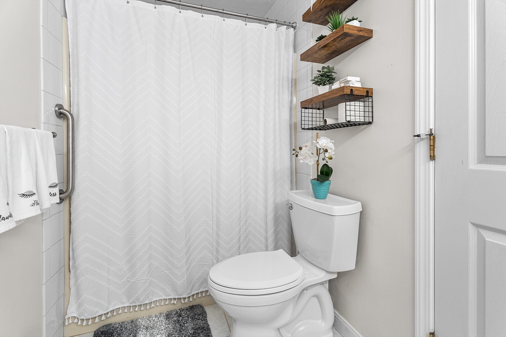 6 Erick Road, Unit 75 Mansfield, MA 02048 - Photo 18 of 20 a white toilet sitting next to a shower curtain