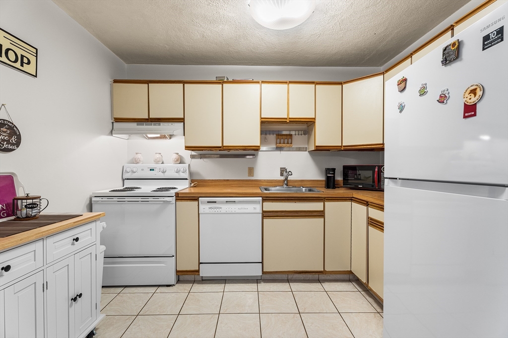 6 Erick Road, Unit 75 Mansfield, MA 02048 - Photo 7 of 20 a kitchen with appliances cabinets and furniture