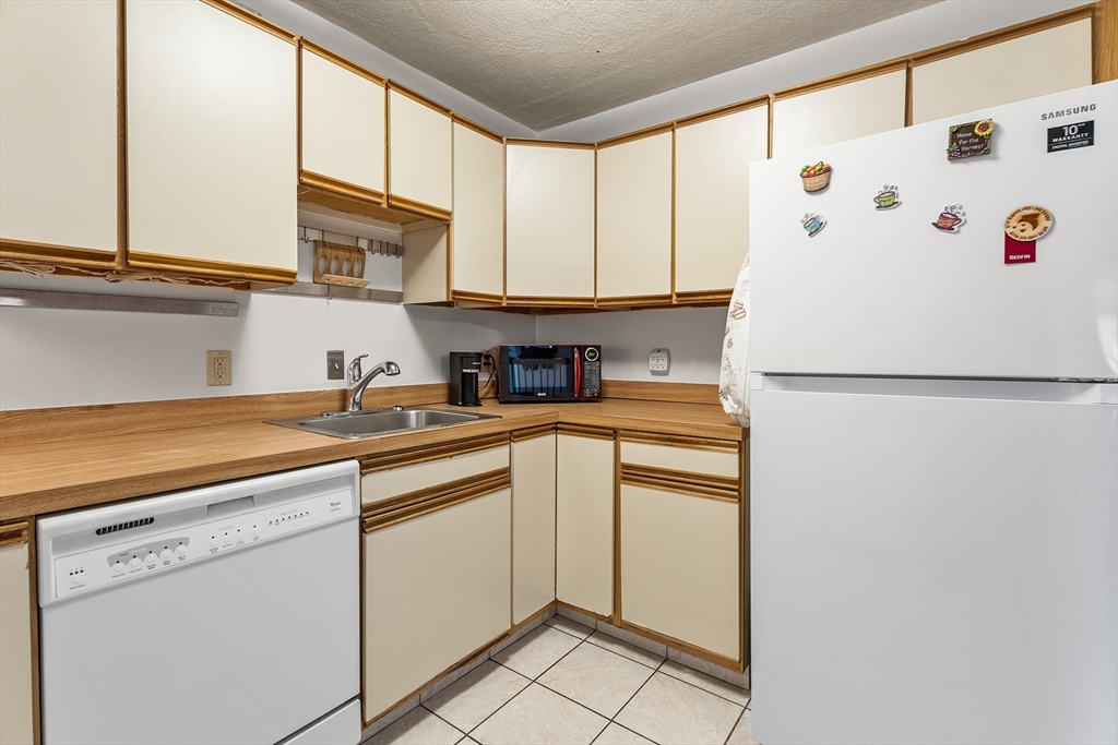 6 Erick Road, Unit 75 Mansfield, MA 02048 - Photo 9 of 20 a kitchen with stainless steel appliances white cabinets and a refrigerator