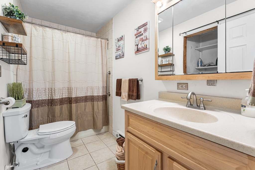 6 Erick Road, Unit 75 Mansfield, MA 02048 - Photo 10 of 20 a bathroom with a sink a toilet and shower curtain