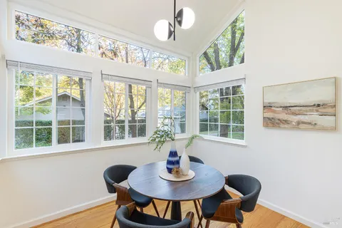 a view of a dining room with furniture a chandelier and wooden floor