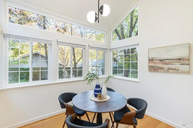 a view of a dining room with furniture a chandelier and wooden floor