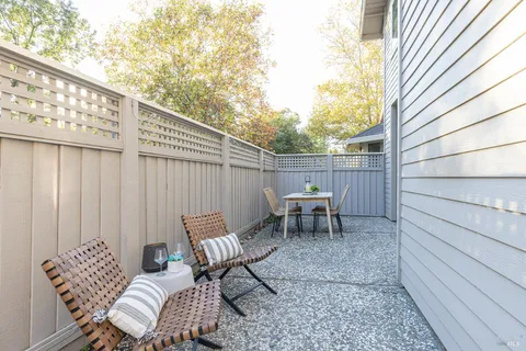 a view of chair and tables in the back yard of a house