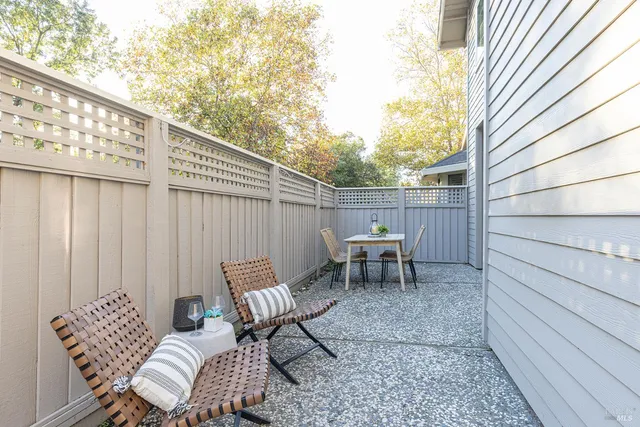 a view of chair and tables in the back yard of a house