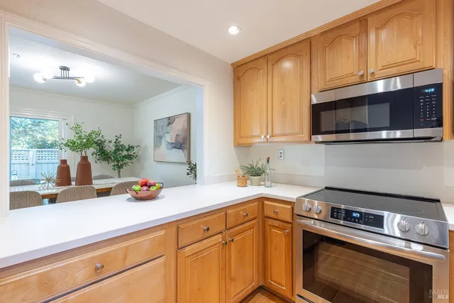 a kitchen with stainless steel appliances a stove a microwave a sink and cabinets