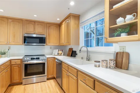 a kitchen with granite countertop a stove a sink and a microwave