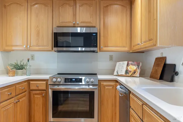 a kitchen with stainless steel appliances granite countertop a sink a stove and a microwave