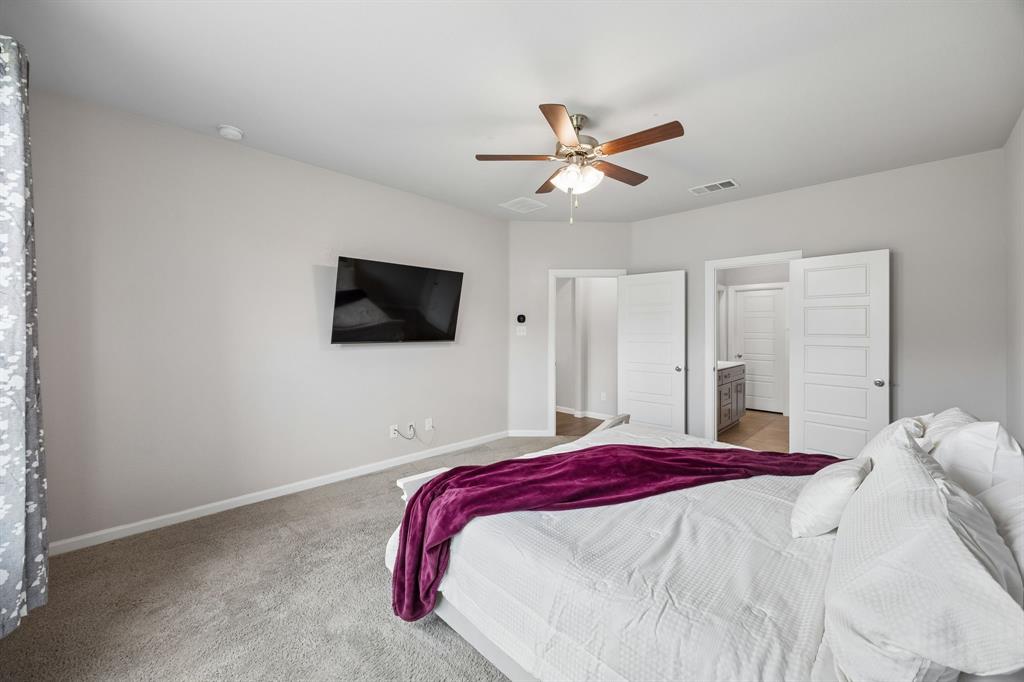 638 Hazeltine Road Red Oak, TX 75154 - Photo 17 of 29 a bedroom with a bed and a flat screen tv