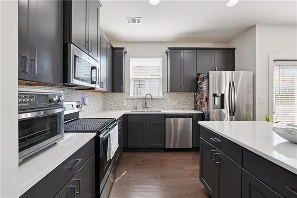a kitchen with stainless steel appliances granite countertop a sink stove and refrigerator