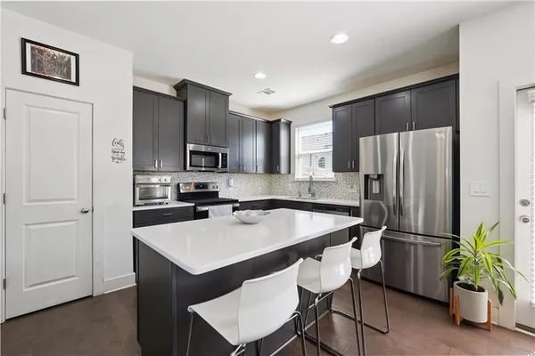 a kitchen with stainless steel appliances a refrigerator and a stove top oven