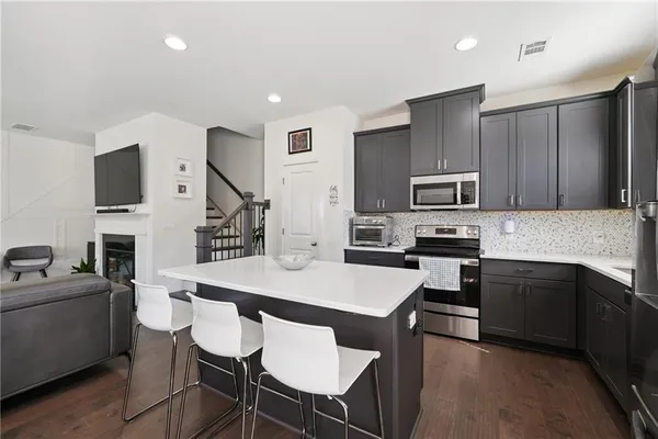 a kitchen with cabinets stainless steel appliances and a dining table