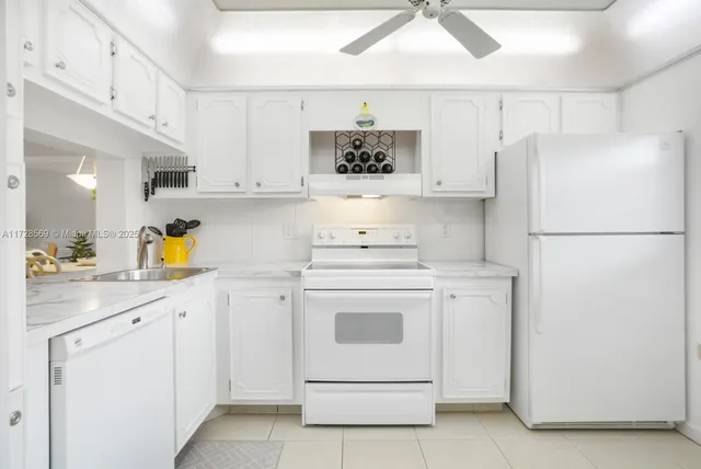 a kitchen with white cabinets and white appliances
