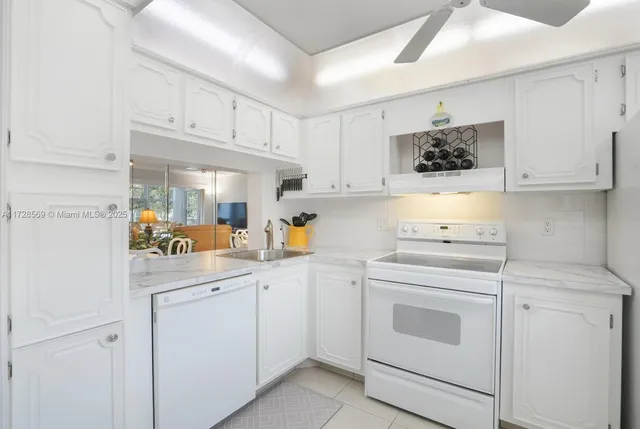 a kitchen with white cabinets and white appliances