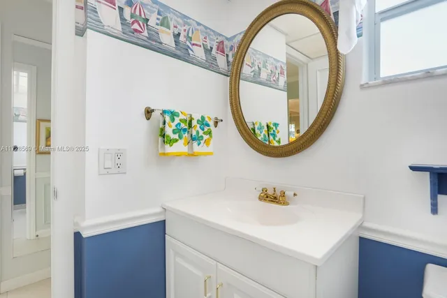 a bathroom with a sink a mirror and a painting on the wall
