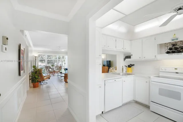 a kitchen with white cabinets and white appliances