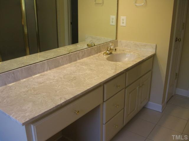 1404 G W Court Raleigh, NC 27603 - Photo 17 of 25 a bathroom with a granite countertop sink and a mirror