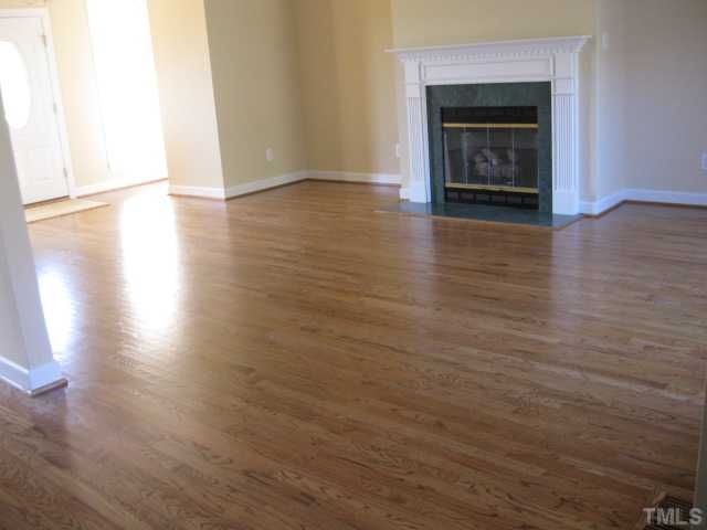 1404 G W Court Raleigh, NC 27603 - Photo 6 of 25 a view of an empty room with wooden floor fireplace and a window