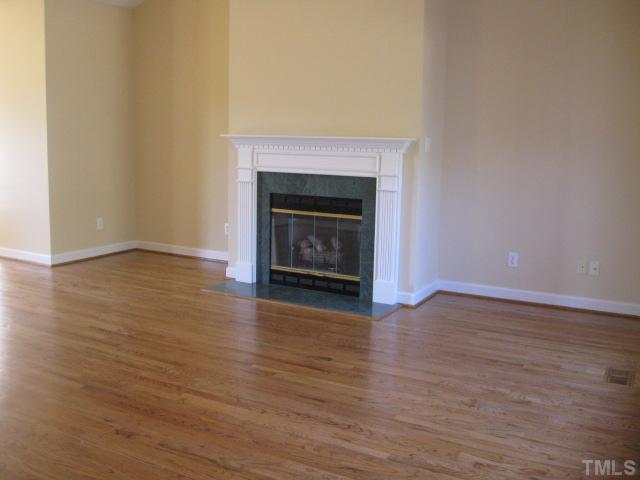 1404 G W Court Raleigh, NC 27603 - Photo 8 of 25 a view of an empty room with wooden floor and a fireplace