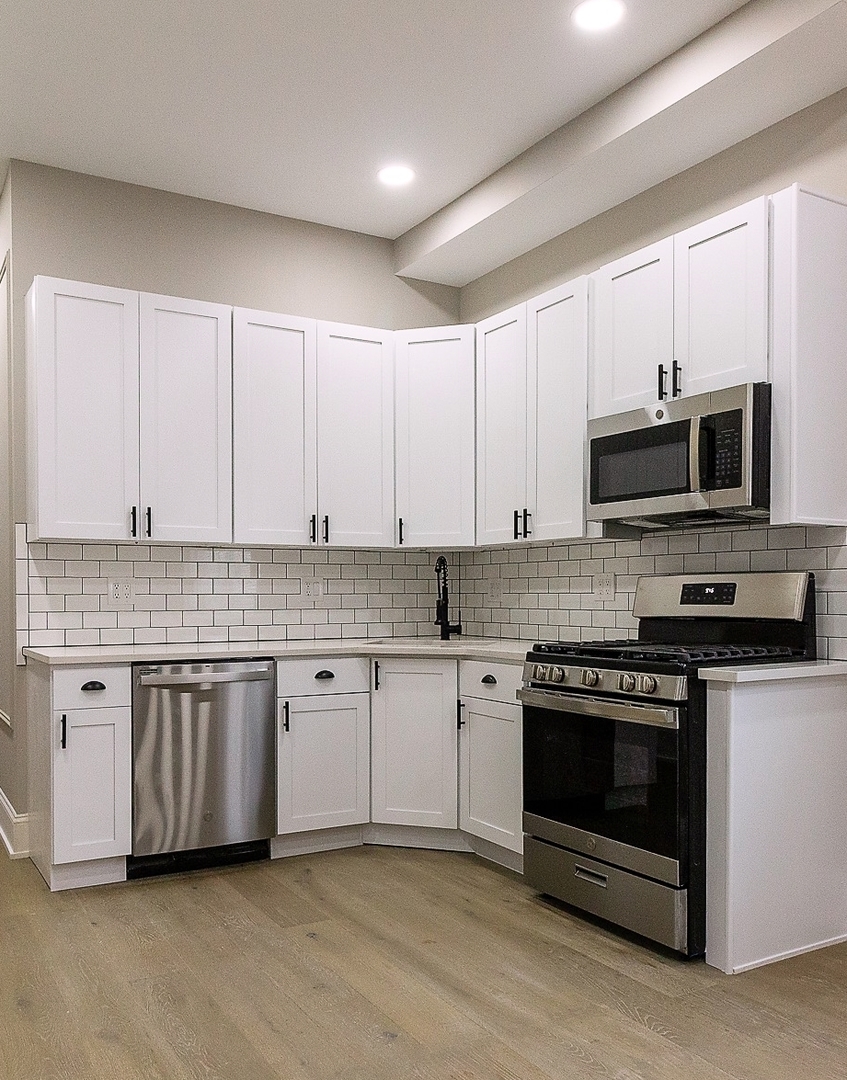 3755 West Addison Street, Unit 2E Chicago, IL 60618 - Photo 2 of 20 a kitchen with granite countertop a stove and a sink