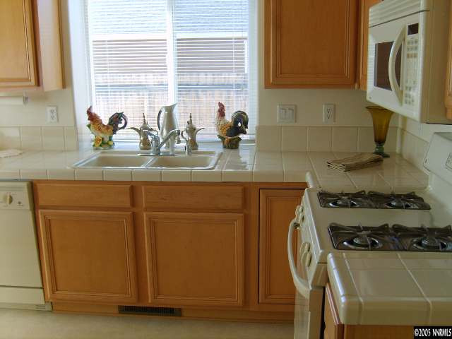 724 Silver Mine Court Reno, NV 89521 - Photo 5 of 9 a kitchen with stainless steel appliances granite countertop a sink stove and cabinets