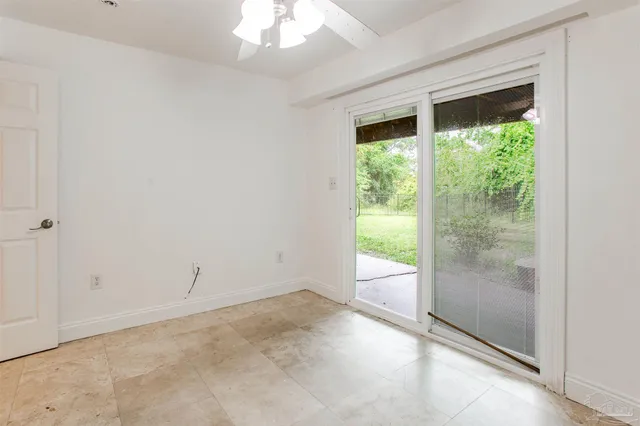 an empty room with a window and a fan
