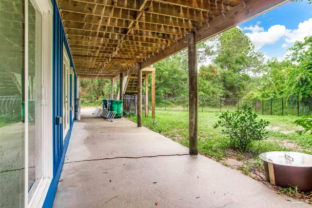 a view of a backyard with plants and wooden fence