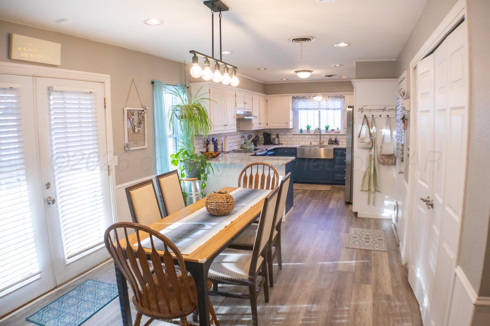 4504 Goodnight Trail Amarillo, TX 79109 - Photo 12 of 32 a dining room with furniture a chandelier and wooden floor