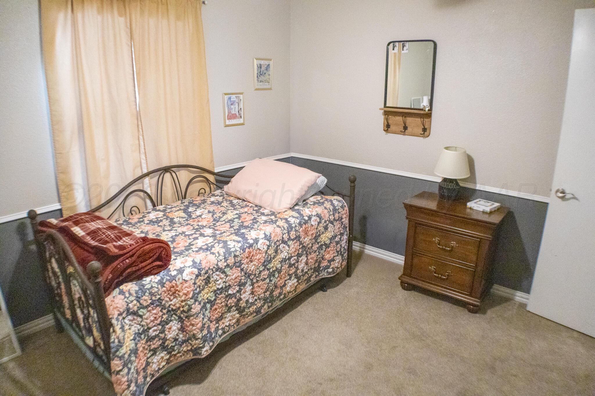 4504 Goodnight Trail Amarillo, TX 79109 - Photo 23 of 32 a bedroom with a bed and a mirror