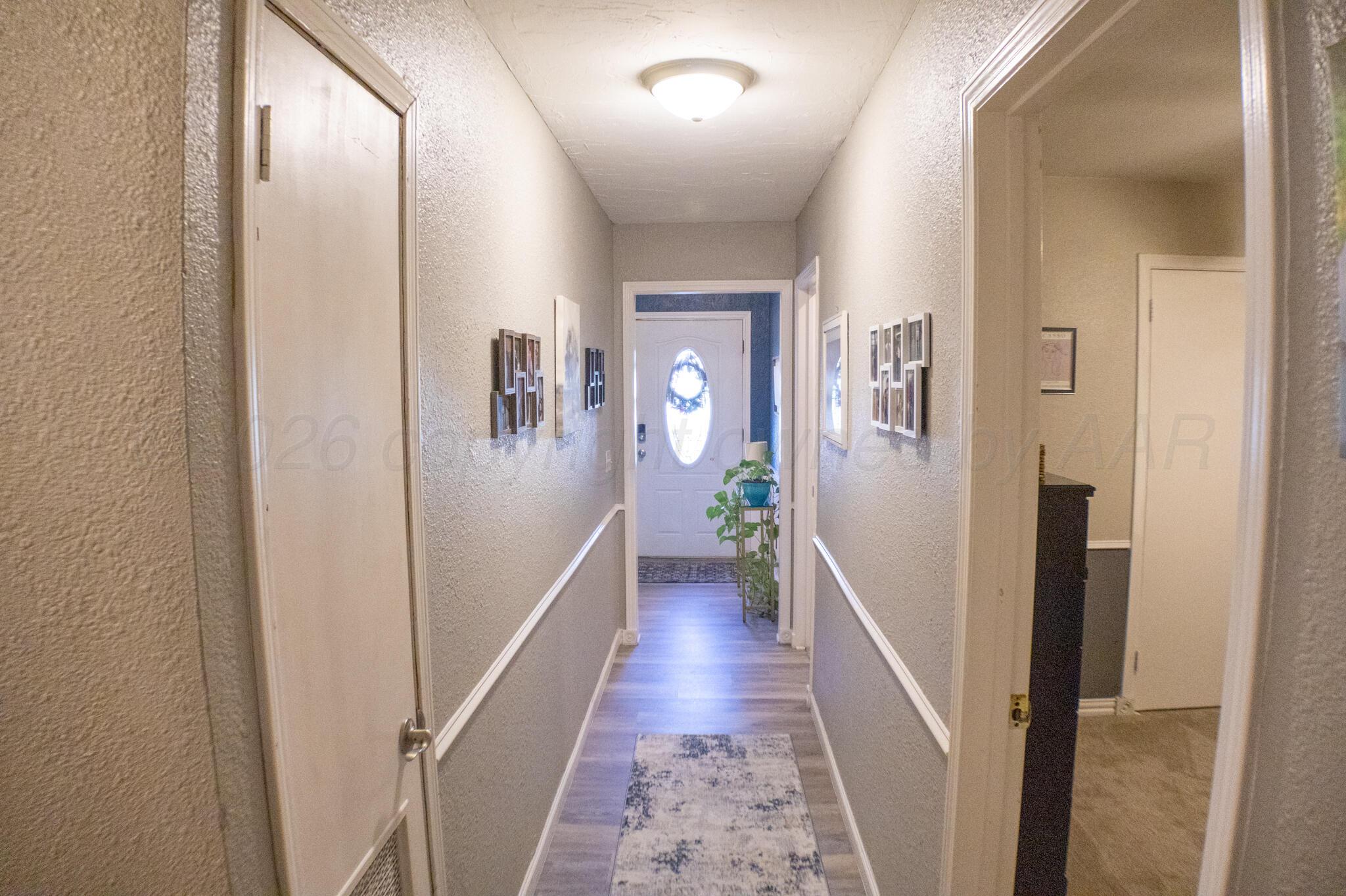 4504 Goodnight Trail Amarillo, TX 79109 - Photo 24 of 32 a hallway with wooden floor and stairs