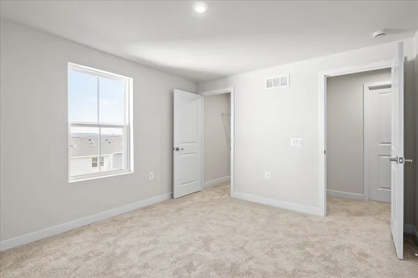 an empty room with windows and closet