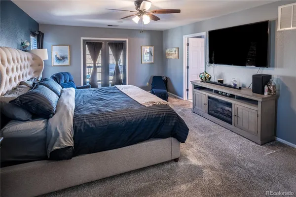 a spacious bedroom with a bed and a flat screen tv