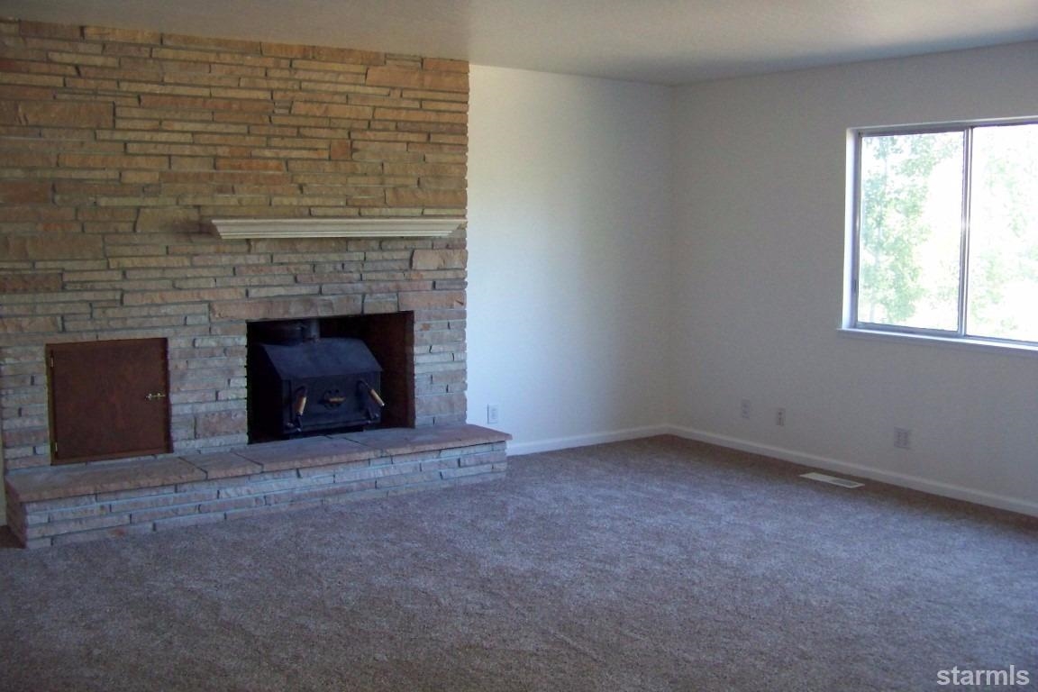 165 Pinion Road Markleeville, CA 96120 - Photo 3 of 34 an empty room with a fireplace and window