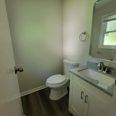 a bathroom with a granite countertop toilet and a sink