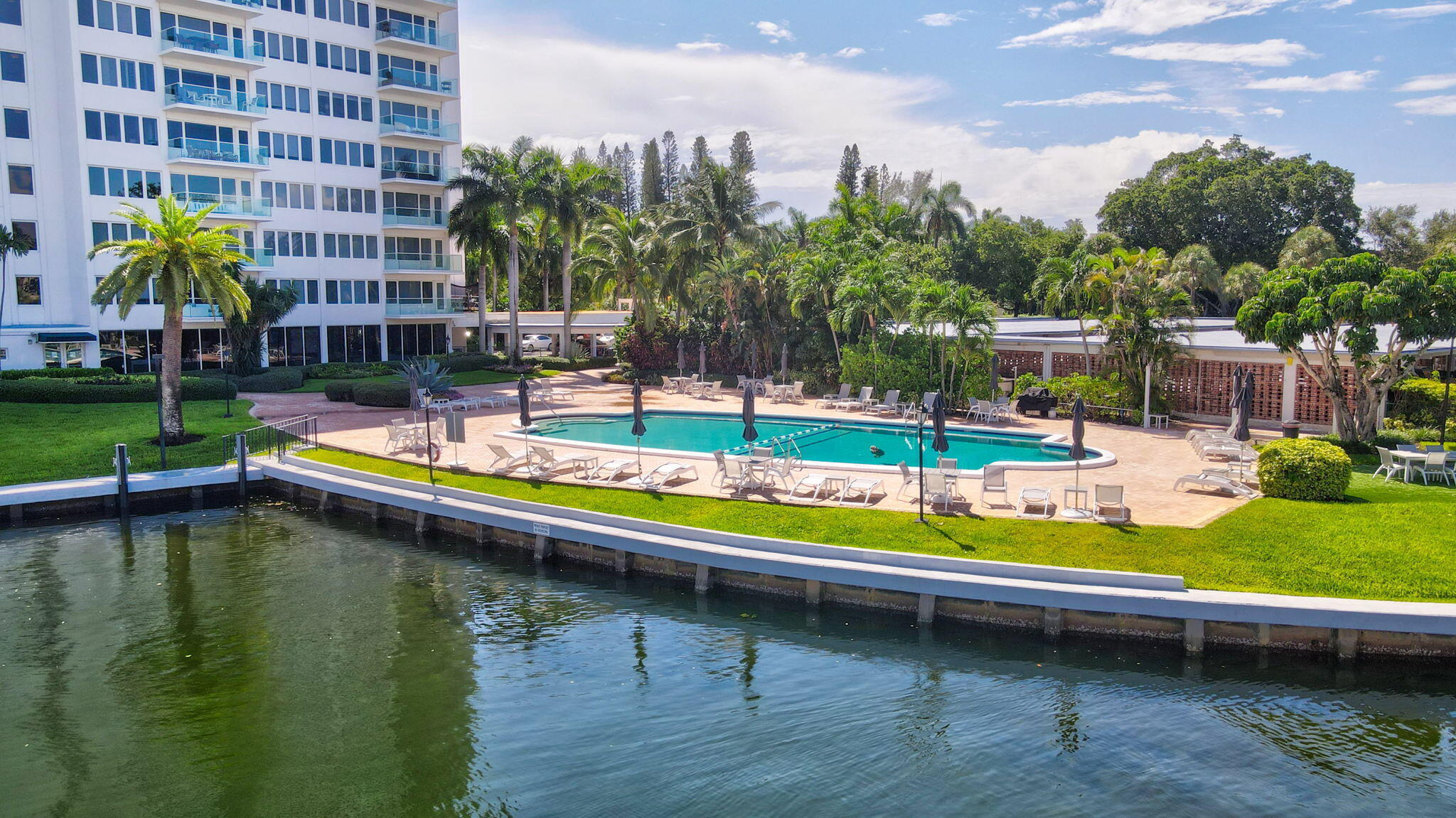 701 East Camino Real, Unit 8F Boca Raton, FL 33432 - Photo 19 of 54 a view of swimming pool with lawn chairs and plants