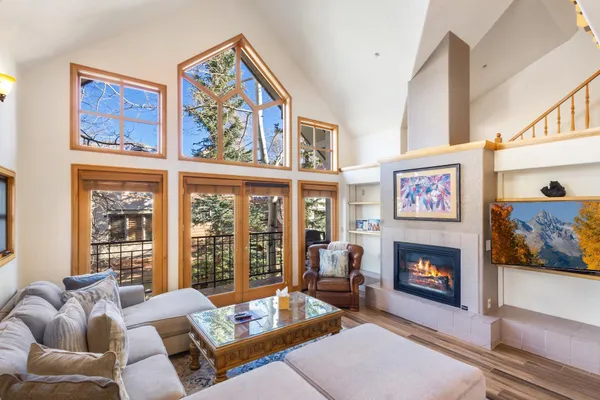 a living room with furniture a fireplace and a large window